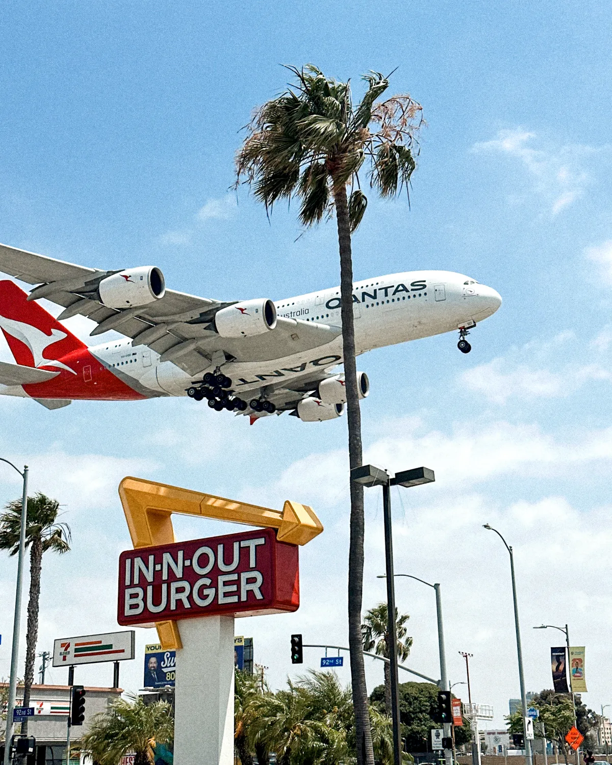 Airliner on final approach above an In-N-Out Burger sign