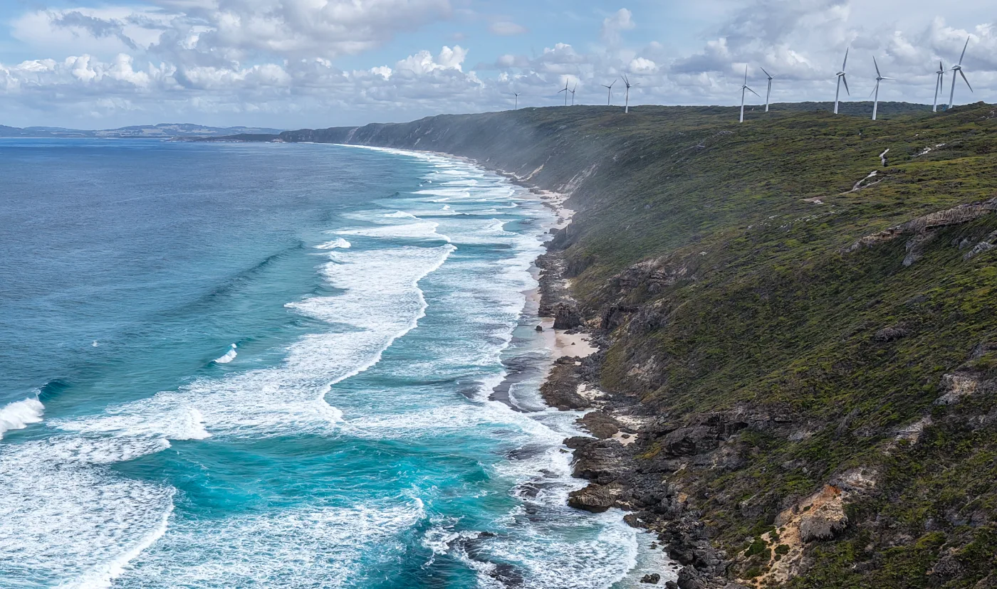 Aerial coastline with wind turbines on the ridge